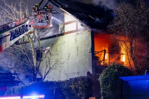 Am Donnerstagmorgen, 04.01.2024 wurde um 07:04 Uhr die Feuerwehr in die Bassenser Straße zu einem Wohnhausbrand gerufen. Beim Eintreffen schlugen den Feuerwehrleuten bereits die Flammen entgegen. Der Brand hatte sich in dem Reihenendhaus über beide Stockwerke und den Dachstuhl ausgebreitet. Umgehend wurde ein umfangreicher Löschangriff vorgenommen. Auch über zwei Drehleitern wurde gelöscht. Während der Brandbekämpfung kam es Durchzündungen, Flammen schlugen meterweit aus dem Gebäude. Ein großes Fensterglas fiel auf die Straße und zersprang in tausende Glassplitter. Bei den Löscharbeiten wurde eine Person tot aufgefunden. Aktuell sind keine weiteren Informationen zur Identität oder Todesumständen bekannt. Die Kriminalpolizei hat die Ermittlungen aufgenommen. Von der Feuerwehr kamen mehrere Löschzüge aus den Nachbargemeinden zum Einsatz. Die Nachlöscharbeiten werden voraussichtlich bis in den Mittag dauern.