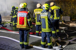 Am Donnerstagmorgen, 04.01.2024 wurde um 07:04 Uhr die Feuerwehr in die Bassenser Straße zu einem Wohnhausbrand gerufen. Beim Eintreffen schlugen den Feuerwehrleuten bereits die Flammen entgegen. Der Brand hatte sich in dem Reihenendhaus über beide Stockwerke und den Dachstuhl ausgebreitet. Umgehend wurde ein umfangreicher Löschangriff vorgenommen. Auch über zwei Drehleitern wurde gelöscht. Während der Brandbekämpfung kam es Durchzündungen, Flammen schlugen meterweit aus dem Gebäude. Ein großes Fensterglas fiel auf die Straße und zersprang in tausende Glassplitter. Bei den Löscharbeiten wurde eine Person tot aufgefunden. Aktuell sind keine weiteren Informationen zur Identität oder Todesumständen bekannt. Die Kriminalpolizei hat die Ermittlungen aufgenommen. Von der Feuerwehr kamen mehrere Löschzüge aus den Nachbargemeinden zum Einsatz. Die Nachlöscharbeiten werden voraussichtlich bis in den Mittag dauern.