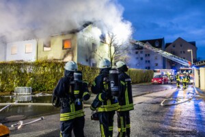 Am Donnerstagmorgen, 04.01.2024 wurde um 07:04 Uhr die Feuerwehr in die Bassenser Straße zu einem Wohnhausbrand gerufen. Beim Eintreffen schlugen den Feuerwehrleuten bereits die Flammen entgegen. Der Brand hatte sich in dem Reihenendhaus über beide Stockwerke und den Dachstuhl ausgebreitet. Umgehend wurde ein umfangreicher Löschangriff vorgenommen. Auch über zwei Drehleitern wurde gelöscht. Während der Brandbekämpfung kam es Durchzündungen, Flammen schlugen meterweit aus dem Gebäude. Ein großes Fensterglas fiel auf die Straße und zersprang in tausende Glassplitter. Bei den Löscharbeiten wurde eine Person tot aufgefunden. Aktuell sind keine weiteren Informationen zur Identität oder Todesumständen bekannt. Die Kriminalpolizei hat die Ermittlungen aufgenommen. Von der Feuerwehr kamen mehrere Löschzüge aus den Nachbargemeinden zum Einsatz. Die Nachlöscharbeiten werden voraussichtlich bis in den Mittag dauern.