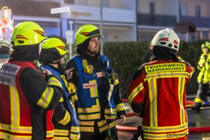 Am Donnerstagmorgen, 04.01.2024 wurde um 07:04 Uhr die Feuerwehr in die Bassenser Straße zu einem Wohnhausbrand gerufen. Beim Eintreffen schlugen den Feuerwehrleuten bereits die Flammen entgegen. Der Brand hatte sich in dem Reihenendhaus über beide Stockwerke und den Dachstuhl ausgebreitet. Umgehend wurde ein umfangreicher Löschangriff vorgenommen. Auch über zwei Drehleitern wurde gelöscht. Während der Brandbekämpfung kam es Durchzündungen, Flammen schlugen meterweit aus dem Gebäude. Ein großes Fensterglas fiel auf die Straße und zersprang in tausende Glassplitter. Bei den Löscharbeiten wurde eine Person tot aufgefunden. Aktuell sind keine weiteren Informationen zur Identität oder Todesumständen bekannt. Die Kriminalpolizei hat die Ermittlungen aufgenommen. Von der Feuerwehr kamen mehrere Löschzüge aus den Nachbargemeinden zum Einsatz. Die Nachlöscharbeiten werden voraussichtlich bis in den Mittag dauern.