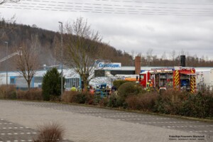 Am Samstagvormittag, 03.02.2024 kam es in Goldbach zu einem Brand in einen Metall- und Galvanikbetrieb. Gegen 11:20 Uhr meldeten zahlreiche Anrufer Feuer und enormer Rauch aus der Fertigungshalle des Betriebes im Erlengrund. Aufgrund der zahlreichen Meldungen wurden gleich mehrere Feuerwehren alarmiert. Im Betrieb wurde am Samstag nicht gearbeitet. Die Löschmaßnahmen der Einsatzkräfte zeigten schnell Wirkung und der Brand konnte unter Kontrolle gebracht werden. In einem Galvanikbetrieb werden chemische Bäder zur Behandlung von Metallen eingesetzt. Diese stellen eine potenzielle Gefahr für Anwohner und Einsatzkräfte dar. Nach aktuellen Information waren die Chemiebäder von dem Brand nicht betroffen. Dennoch entschied die Einsatzleitung, dass alle Feuerwehrleute, welche in der Halle gearbeitet hatten, vorsorglich dekontaminiert und Messungen in der Umgebung durchgeführt werden. Hierzu rückten Spezialkräfte der Feuerwehr aus Großostheim und Stockstadt an. Es kam ein Messwagen der Feuerwehr in der Umgebung der Brandstelle zum Einsatz. Schadstoffe wurden keine festgestellt. Während des Einsatzes meldeten sich drei Passanten, die sich bei Brandausbruch in unmittelbarer Nähe des Brandobjektes aufgehalten hatten. Die betroffene Halle liegt in direkter Nachbarschaft zu gleich drei Einkaufsmärkten. Sie wurden von einem Notarzt untersucht und mussten sich aber keiner Behandlung unterziehen.