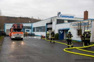 Am Samstagvormittag, 03.02.2024 kam es in Goldbach zu einem Brand in einen Metall- und Galvanikbetrieb. Gegen 11:20 Uhr meldeten zahlreiche Anrufer Feuer und enormer Rauch aus der Fertigungshalle des Betriebes im Erlengrund. Aufgrund der zahlreichen Meldungen wurden gleich mehrere Feuerwehren alarmiert. Im Betrieb wurde am Samstag nicht gearbeitet. Die Löschmaßnahmen der Einsatzkräfte zeigten schnell Wirkung und der Brand konnte unter Kontrolle gebracht werden. In einem Galvanikbetrieb werden chemische Bäder zur Behandlung von Metallen eingesetzt. Diese stellen eine potenzielle Gefahr für Anwohner und Einsatzkräfte dar. Nach aktuellen Information waren die Chemiebäder von dem Brand nicht betroffen. Dennoch entschied die Einsatzleitung, dass alle Feuerwehrleute, welche in der Halle gearbeitet hatten, vorsorglich dekontaminiert und Messungen in der Umgebung durchgeführt werden. Hierzu rückten Spezialkräfte der Feuerwehr aus Großostheim und Stockstadt an. Es kam ein Messwagen der Feuerwehr in der Umgebung der Brandstelle zum Einsatz. Schadstoffe wurden keine festgestellt. Während des Einsatzes meldeten sich drei Passanten, die sich bei Brandausbruch in unmittelbarer Nähe des Brandobjektes aufgehalten hatten. Die betroffene Halle liegt in direkter Nachbarschaft zu gleich drei Einkaufsmärkten. Sie wurden von einem Notarzt untersucht und mussten sich aber keiner Behandlung unterziehen.