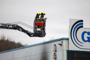 Am Samstagvormittag, 03.02.2024 kam es in Goldbach zu einem Brand in einen Metall- und Galvanikbetrieb. Gegen 11:20 Uhr meldeten zahlreiche Anrufer Feuer und enormer Rauch aus der Fertigungshalle des Betriebes im Erlengrund. Aufgrund der zahlreichen Meldungen wurden gleich mehrere Feuerwehren alarmiert. Im Betrieb wurde am Samstag nicht gearbeitet. Die Löschmaßnahmen der Einsatzkräfte zeigten schnell Wirkung und der Brand konnte unter Kontrolle gebracht werden. In einem Galvanikbetrieb werden chemische Bäder zur Behandlung von Metallen eingesetzt. Diese stellen eine potenzielle Gefahr für Anwohner und Einsatzkräfte dar. Nach aktuellen Information waren die Chemiebäder von dem Brand nicht betroffen. Dennoch entschied die Einsatzleitung, dass alle Feuerwehrleute, welche in der Halle gearbeitet hatten, vorsorglich dekontaminiert und Messungen in der Umgebung durchgeführt werden. Hierzu rückten Spezialkräfte der Feuerwehr aus Großostheim und Stockstadt an. Es kam ein Messwagen der Feuerwehr in der Umgebung der Brandstelle zum Einsatz. Schadstoffe wurden keine festgestellt. Während des Einsatzes meldeten sich drei Passanten, die sich bei Brandausbruch in unmittelbarer Nähe des Brandobjektes aufgehalten hatten. Die betroffene Halle liegt in direkter Nachbarschaft zu gleich drei Einkaufsmärkten. Sie wurden von einem Notarzt untersucht und mussten sich aber keiner Behandlung unterziehen.