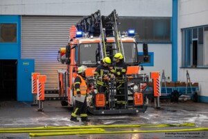 Am Samstagvormittag, 03.02.2024 kam es in Goldbach zu einem Brand in einen Metall- und Galvanikbetrieb. Gegen 11:20 Uhr meldeten zahlreiche Anrufer Feuer und enormer Rauch aus der Fertigungshalle des Betriebes im Erlengrund. Aufgrund der zahlreichen Meldungen wurden gleich mehrere Feuerwehren alarmiert. Im Betrieb wurde am Samstag nicht gearbeitet. Die Löschmaßnahmen der Einsatzkräfte zeigten schnell Wirkung und der Brand konnte unter Kontrolle gebracht werden. In einem Galvanikbetrieb werden chemische Bäder zur Behandlung von Metallen eingesetzt. Diese stellen eine potenzielle Gefahr für Anwohner und Einsatzkräfte dar. Nach aktuellen Information waren die Chemiebäder von dem Brand nicht betroffen. Dennoch entschied die Einsatzleitung, dass alle Feuerwehrleute, welche in der Halle gearbeitet hatten, vorsorglich dekontaminiert und Messungen in der Umgebung durchgeführt werden. Hierzu rückten Spezialkräfte der Feuerwehr aus Großostheim und Stockstadt an. Es kam ein Messwagen der Feuerwehr in der Umgebung der Brandstelle zum Einsatz. Schadstoffe wurden keine festgestellt. Während des Einsatzes meldeten sich drei Passanten, die sich bei Brandausbruch in unmittelbarer Nähe des Brandobjektes aufgehalten hatten. Die betroffene Halle liegt in direkter Nachbarschaft zu gleich drei Einkaufsmärkten. Sie wurden von einem Notarzt untersucht und mussten sich aber keiner Behandlung unterziehen.